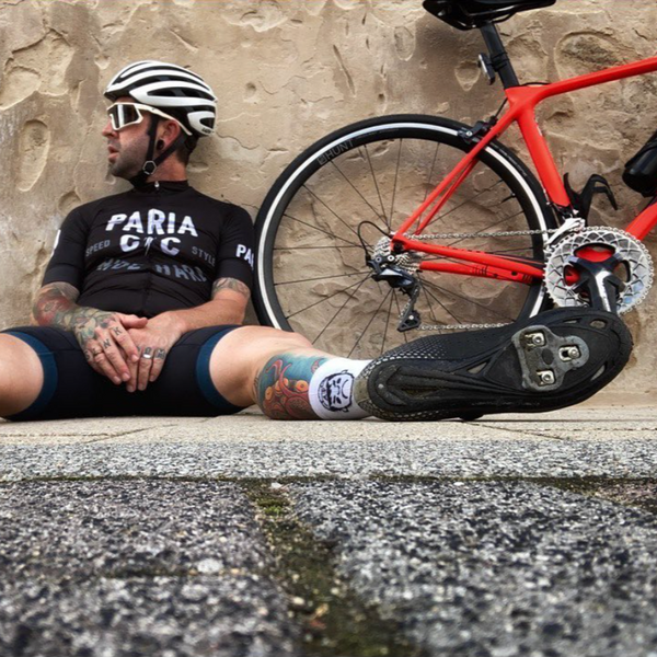 Road cyclist sitting on the ground next to his bicycle