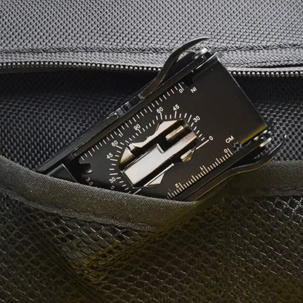 Multitool with compass and ruler in a pocket of a dark bag