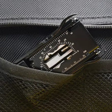Multitool with compass and ruler in a pocket of a dark bag