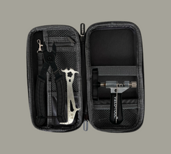 Black tool case with various tools inside on a gray background