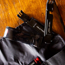 Velotool bike tool kit on a black bag with wooden surface background