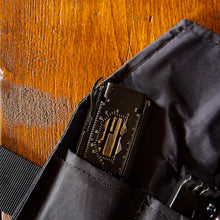 Black bag with a visible brand logo on a wooden surface