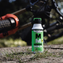 Green and white bottle of Magic Milk with a blurred background of a bike and nature.