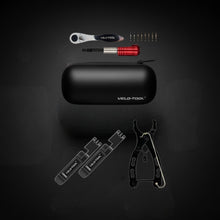 Collection of bicycle tools including a black tool case, wrenches, and other tools on a dark background.
