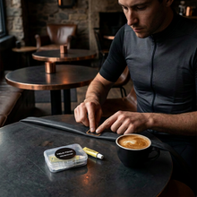 Cyclist patching a TPU inner tube at a café table